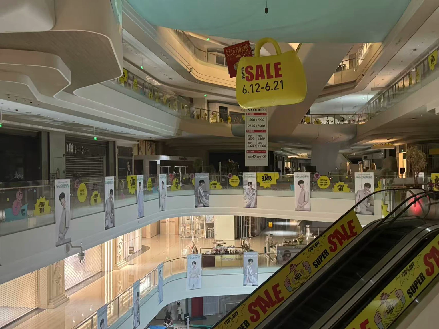 Large campaign banners and railing graphics in a shopping-centre atrium